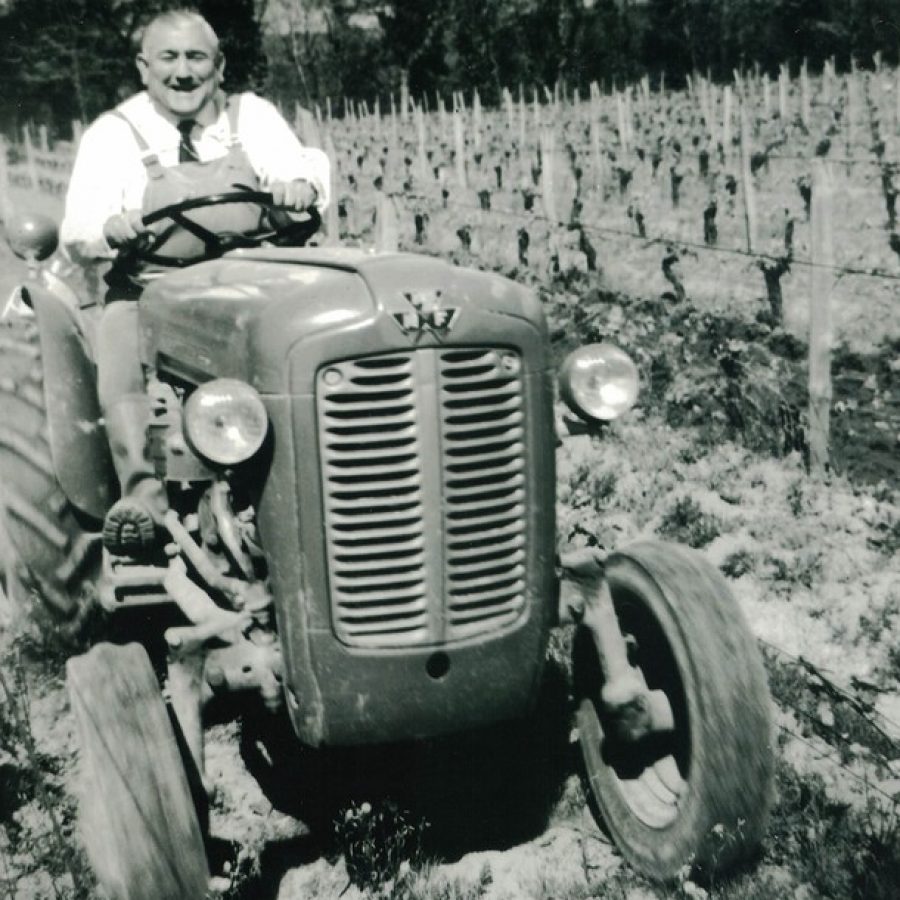 Old man Bourlon sits on a tractor in his vineyard